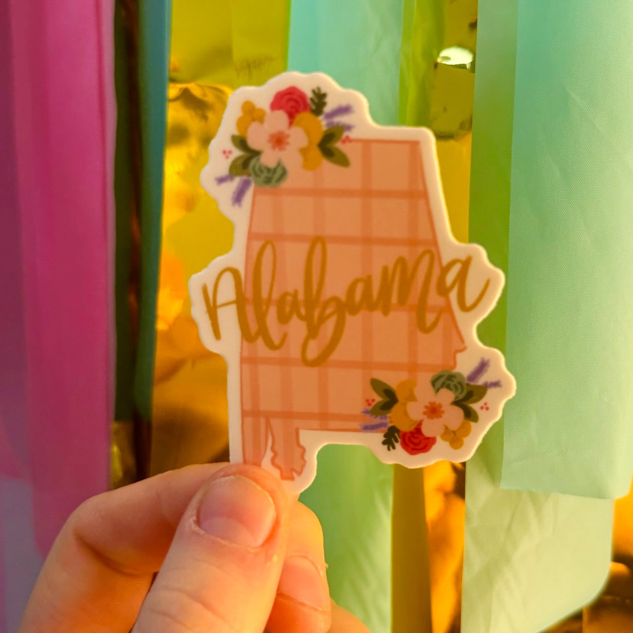 Doodles by Rebekah Alabama state pride sticker. This whimsical hand-painted vinyl decal with a pink checkered pattern and floral accents is a perfect gift for Alabamians to decorate water bottles, laptops, and planners.
