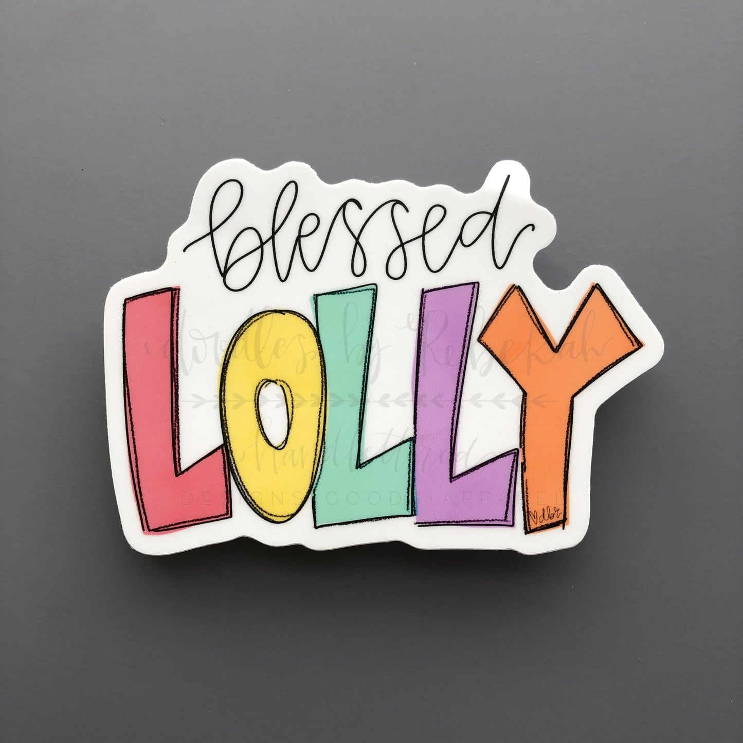Colorful sticker reading "Blessed Lolly" in Rebekah's handwriting