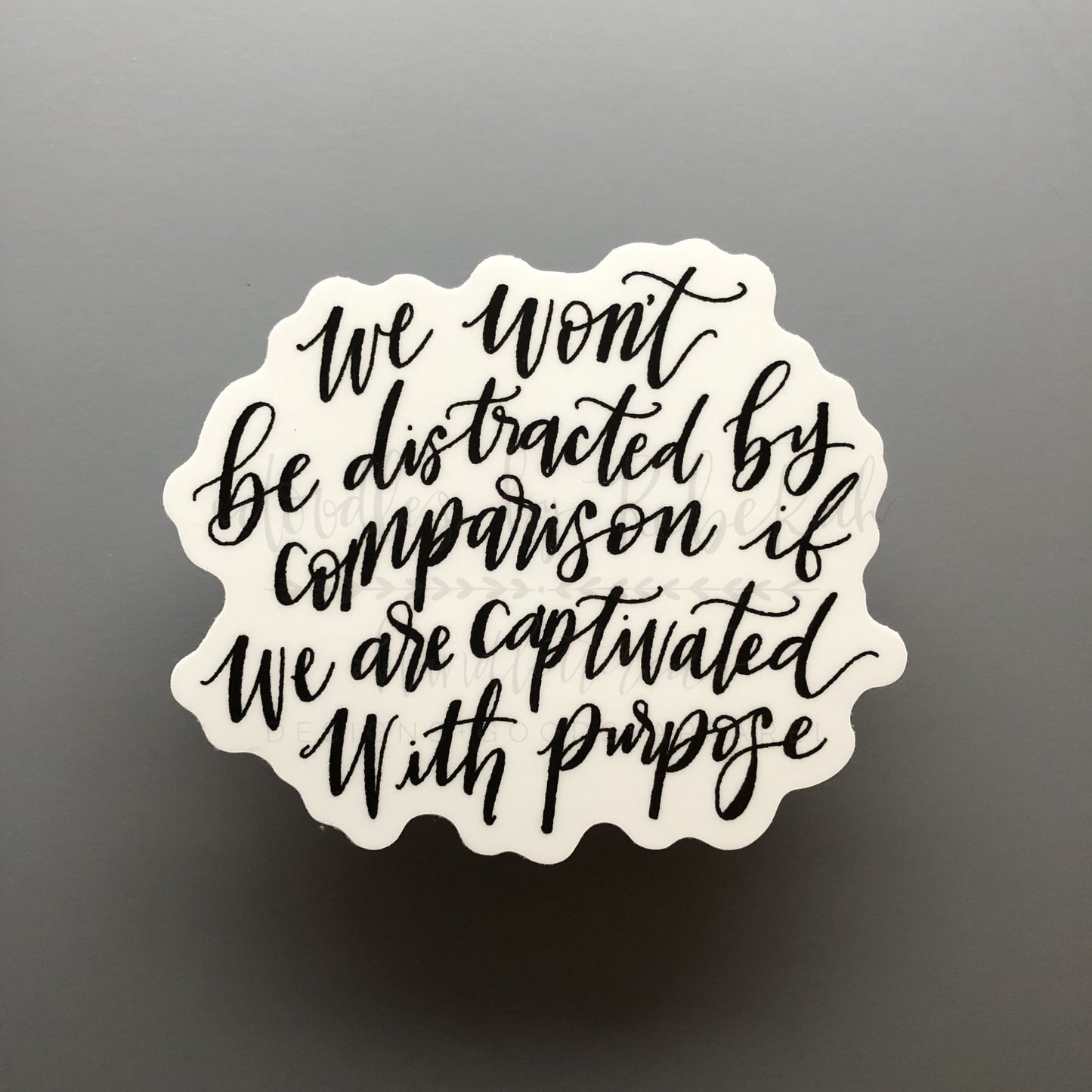 A white sticker with Rebekah's word are that reads " we on't be distracted by comparison if we are captivated with purpose"