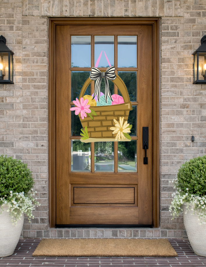 Doodles by Rebekah Easter basket door decor featuring a whimsical hand-painted basket with colorful eggs and a striped bow on a rustic front porch.