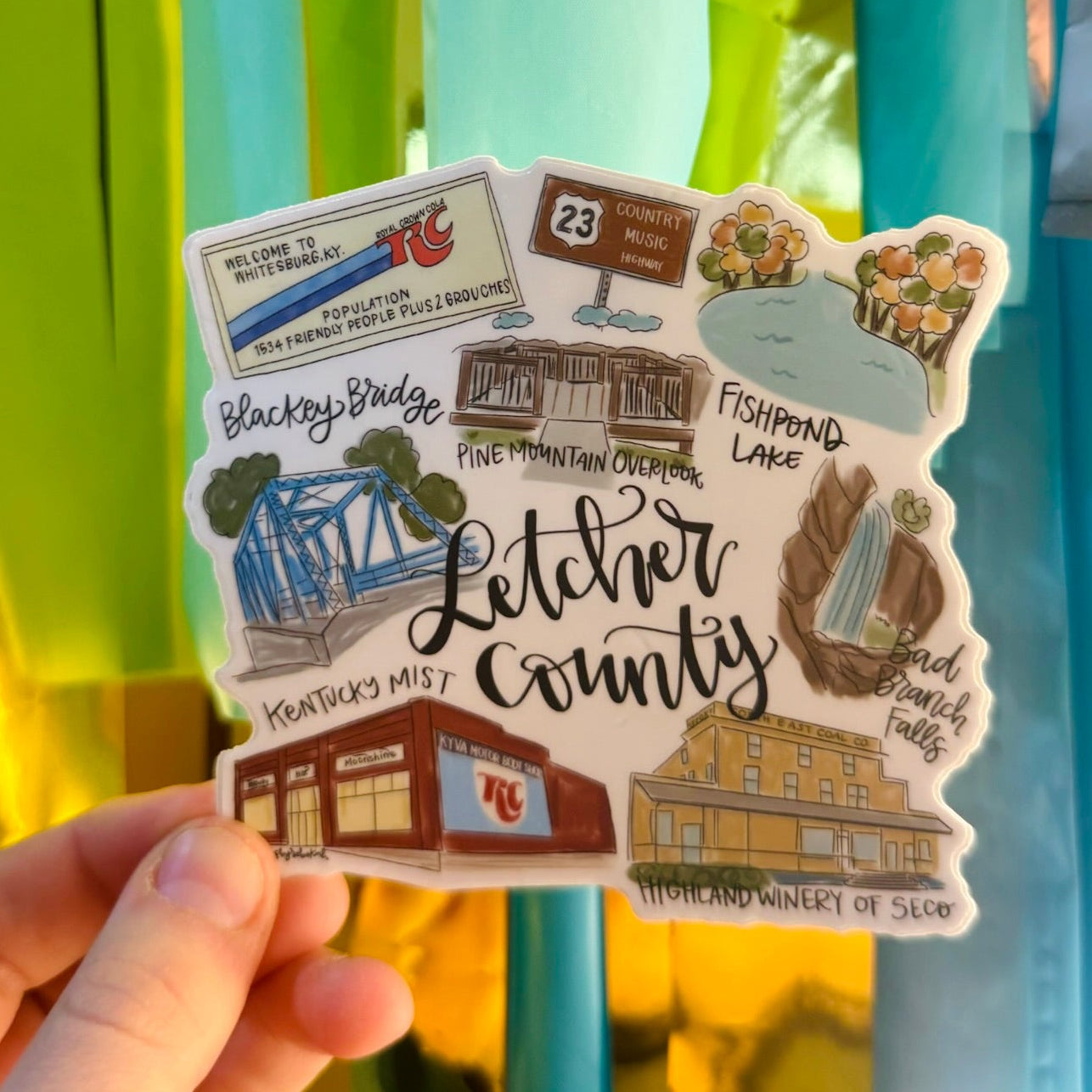 Doodles by Rebekah Letcher County Kentucky souvenir sticker. This whimsical hand-painted vinyl decal features local landmarks like Blackey Bridge and Fishpond Lake, making it a perfect gift for residents of Whitesburg or Letcher County to display on water bottles and laptops.