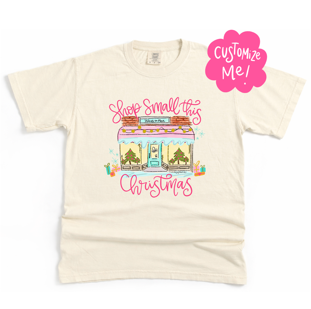 Beige t-shirt with Christmas-themed graphic and 'Shop Small this Christmas' text on a white background.