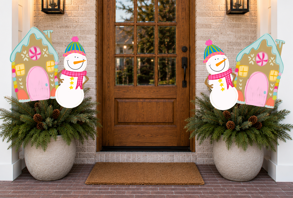 Decorative snowmen and gingerbread house planters on either side of a wooden door.