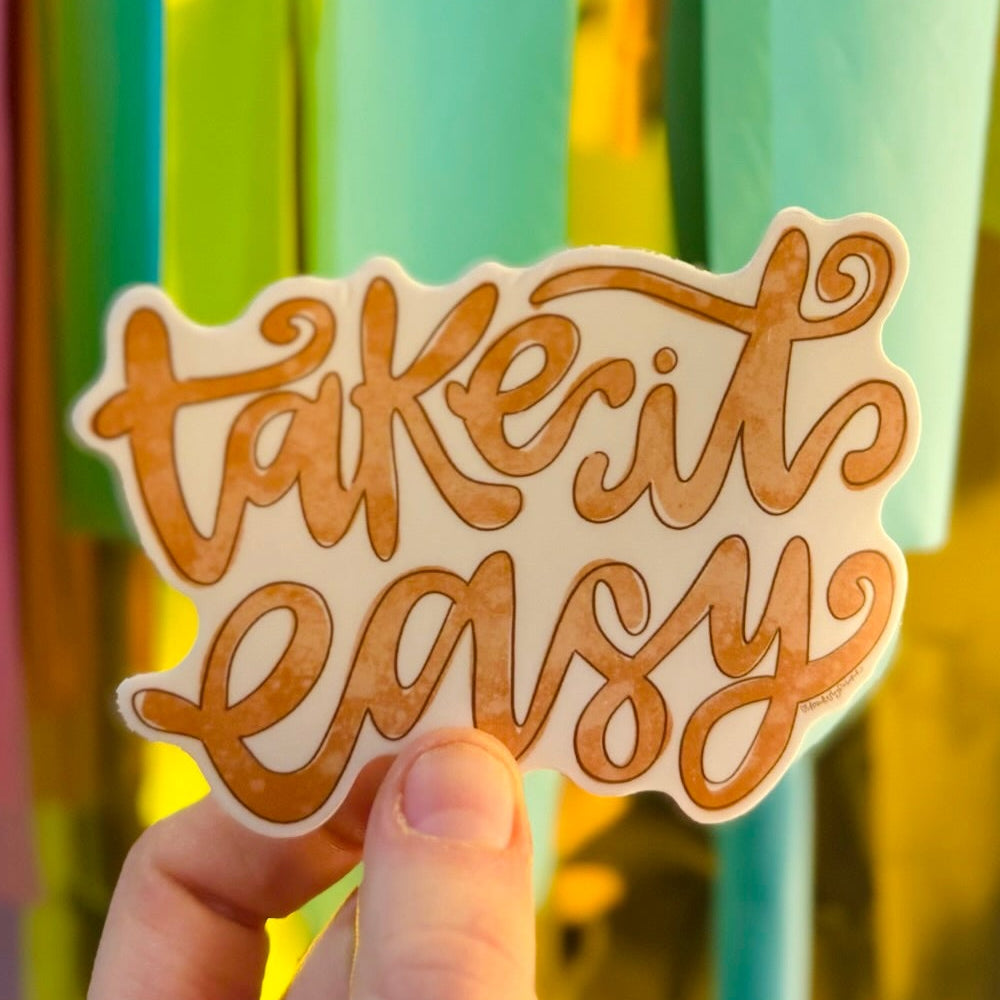 Doodles by Rebekah "Take it Easy" motivational sticker. This hand-painted, boho-style vinyl decal is a perfect reminder for self-care and mental wellness, ideal for decorating water bottles, laptops, and planners.