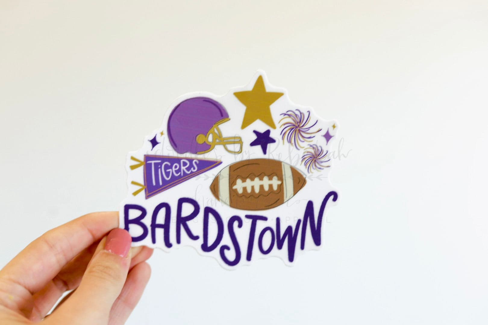 A sticker with a purple and white color scheme featuring text 'BARDSTOWN' and 'TIGERS' along with an image of a football helmet, stars, and a football.
