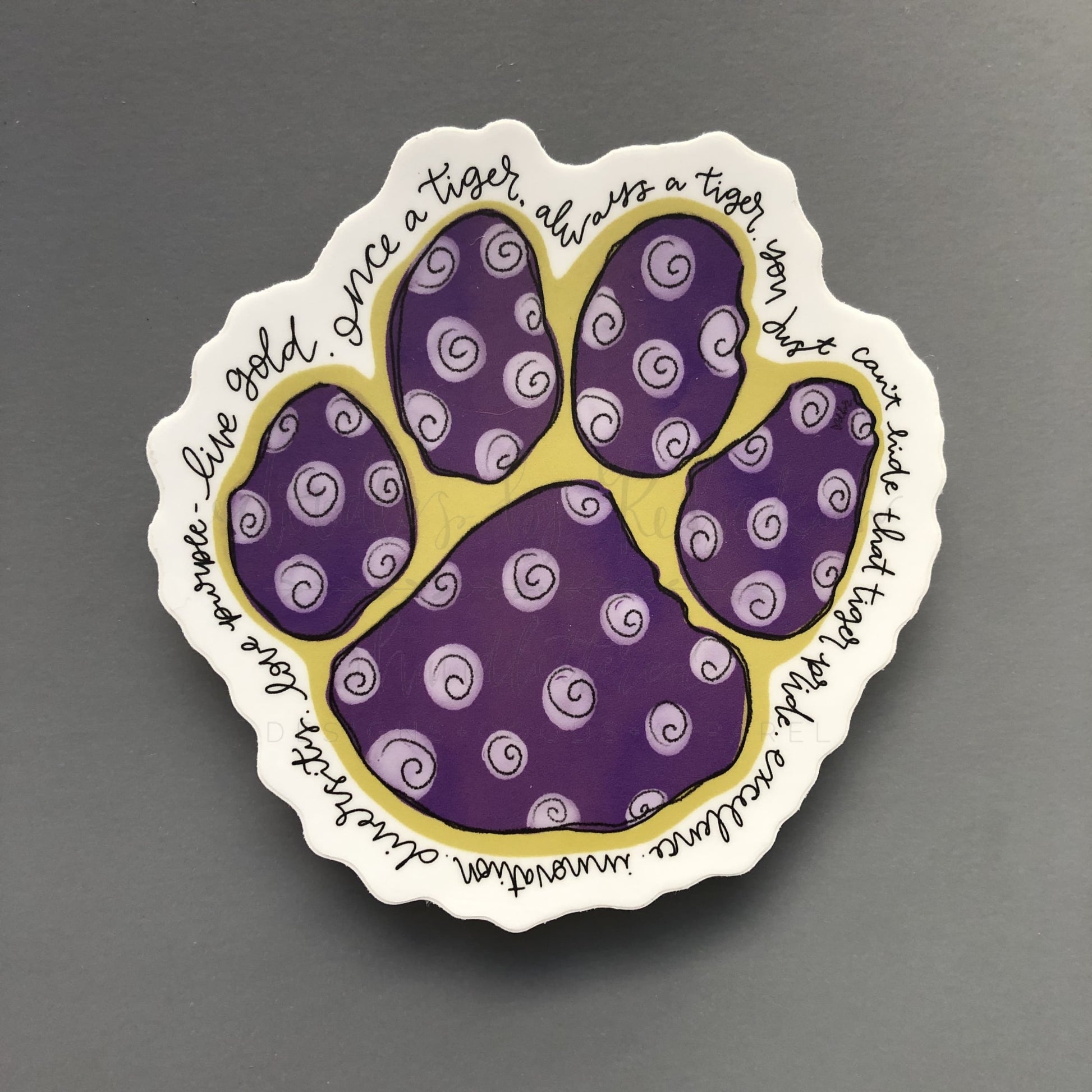 A sticker with a design resembling a paw print containing purple patterns on a white background, with text that includes ' Bardstown Tigers.'.