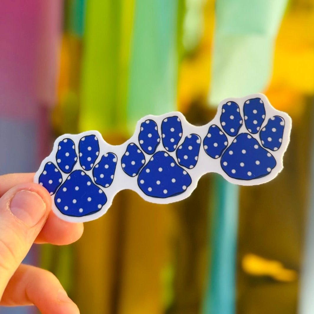 Doodles by Rebekah blue and white polka dot paw prints sticker. This whimsical hand-painted vinyl decal is perfect for showing school spirit or team pride on water bottles, laptops, and planners.