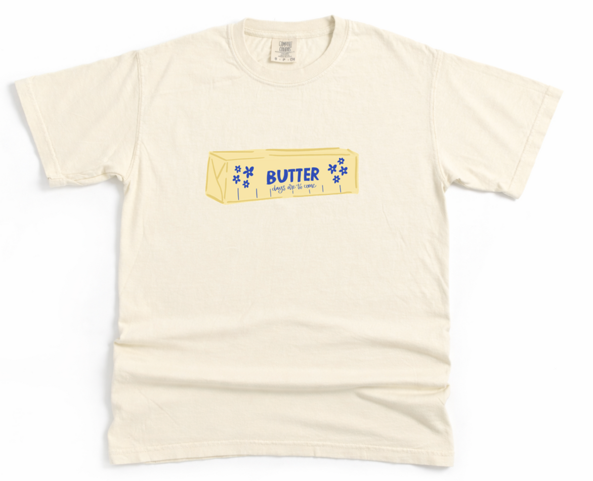 Beige t-shirt with a graphic of a butter container on a white background