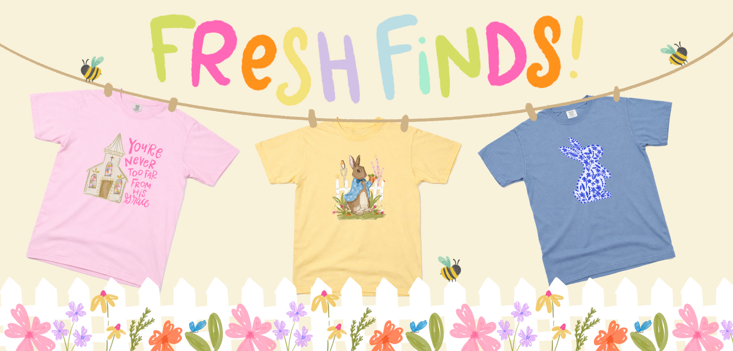 Three t-shirts hanging on a line with colorful text 'Fresh Finds!' and floral decorations.