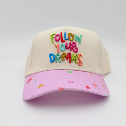 Cap with 'Follow Your Dreams' text on a light gray background