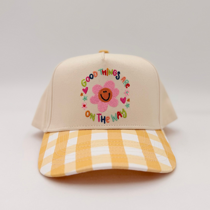 Beige cap with floral design and text on a light gray background