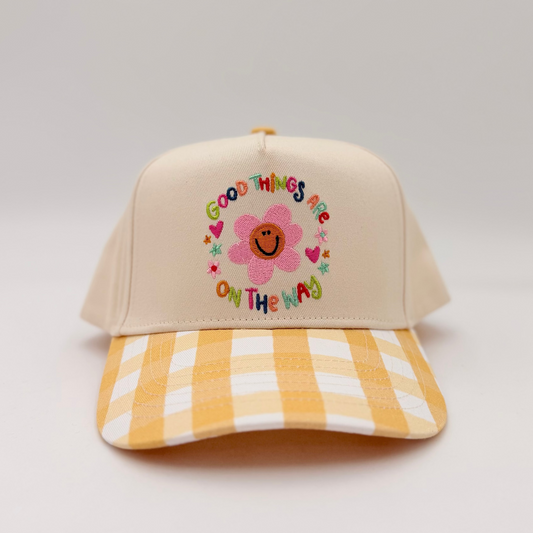 Beige cap with floral design and text on a light gray background