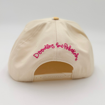 Beige cap with pink text on a light gray background
