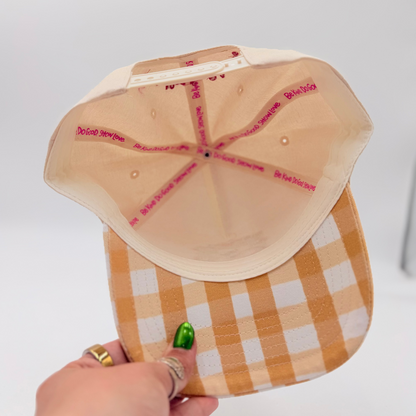 Hand holding a checkered cap with a paper template on a white background
