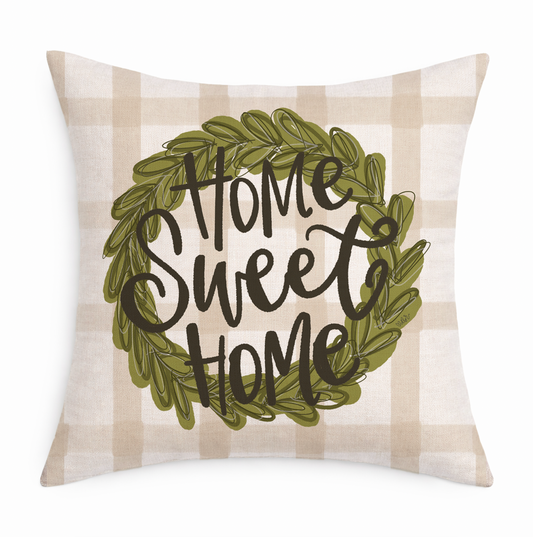 a gingham pillow with a wreath circling "Home Sweet Home" on a white background