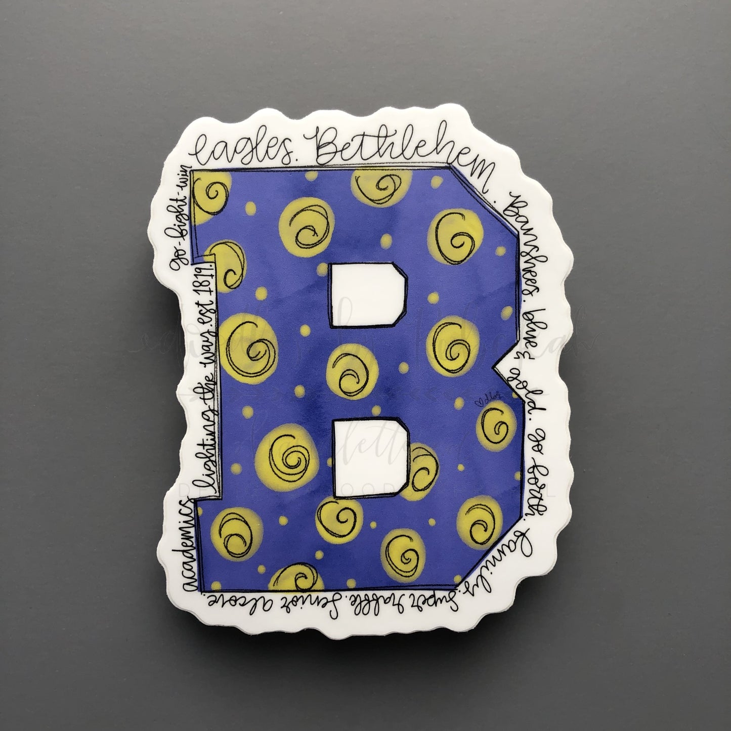 Bethlehem High School spirit sticker featuring a blue and gold "B" with "Eagles," "Banshees," and "lighting the way" calligraphy.