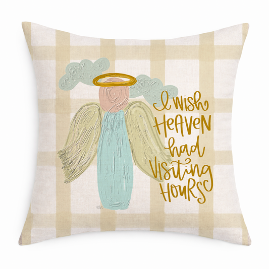 Decorative pillow with angel illustration and text on a plaid background