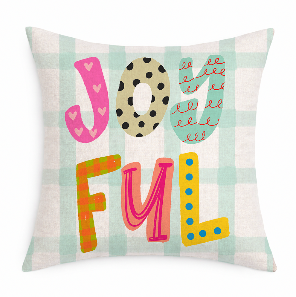 Decorative pillow with colorful letters spelling 'JOYFUL' on a striped background