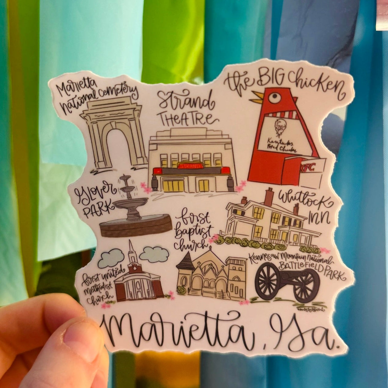 Doodles by Rebekah Marietta, Georgia landmarks vinyl sticker. This whimsical hand-painted decal features iconic local spots like the Big Chicken and Strand Theatre, making it a perfect hometown gift or souvenir for water bottles, laptops, and planners.