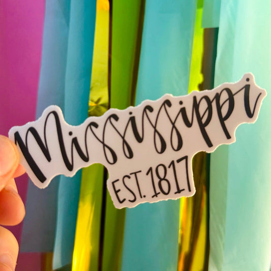 Doodles by Rebekah Mississippi state pride vinyl sticker. This whimsical hand-painted "Mississippi Est. 1817" decal is a perfect gift for residents and travelers to decorate water bottles, laptops, and planners.