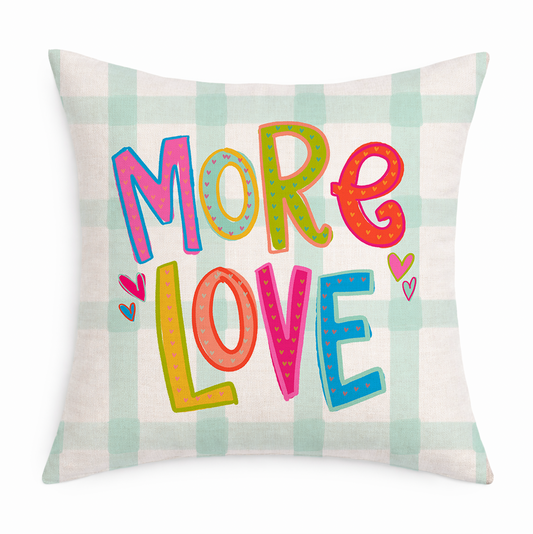 Decorative gingham pillow with the phrase "More Love" in colorful letters on a white background 