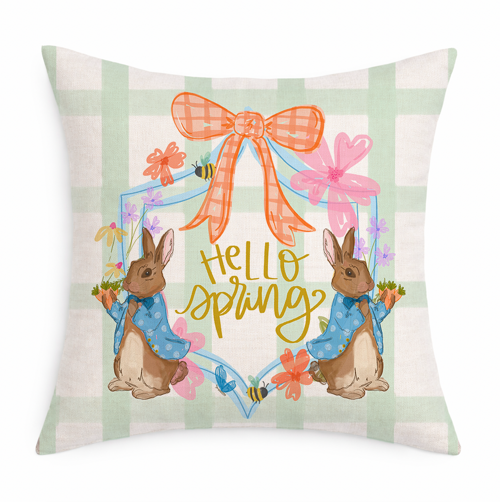 Decorative pillow with 'Hello Spring' text and bunny illustrations on a plaid background.