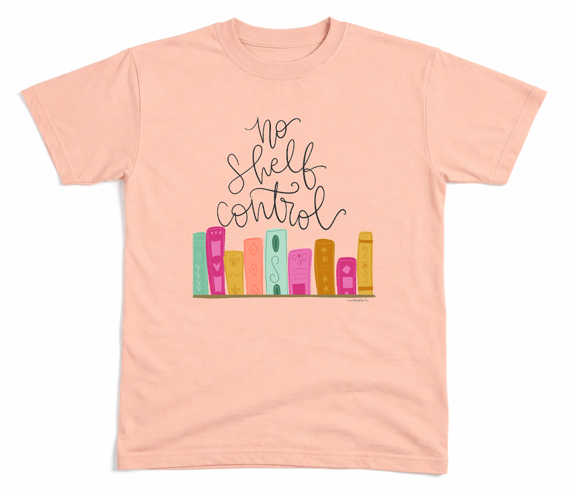 Pink t-shirt with 'No Shelf Control' text and colorful book illustrations on a white background