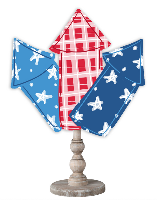 Doodles by Rebekah patriotic 4th of July tabletop decor featuring whimsical firework rocket illustrations on a rustic turned wood stand.