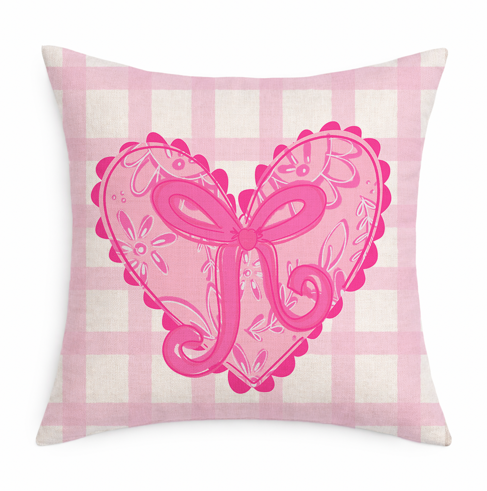Decorative pillow with pink heart and bow design on a pink and white checkered background