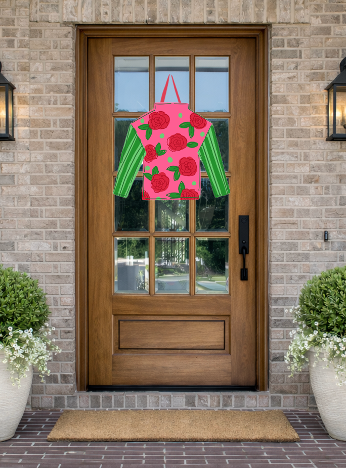 Doodles by Rebekah Kentucky Derby door decor featuring a pink and green jockey silk door hanger with a red rose pattern on a rustic front porch.