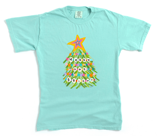 Light blue t-shirt with a colorful Christmas tree design and 'Merry and Bright' text on a white background.