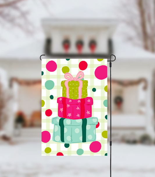 Decorative garden flag with colorful gift boxes on a polka dot background, displayed outdoors.
