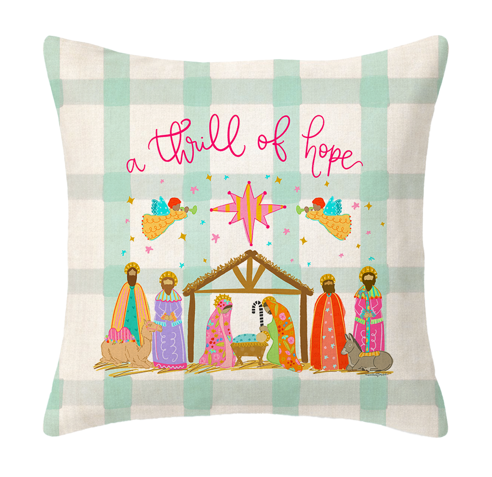 Decorative pillow with nativity scene and 'a thrill of hope' text on a plaid background