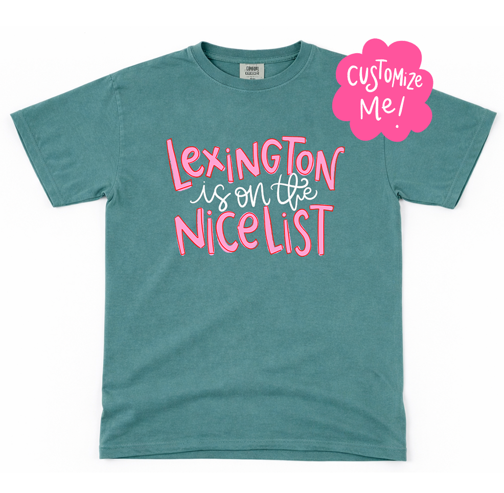 Teal t-shirt with pink text 'Lexington is on the nicelist' and a 'Customize Me!' label on a white background