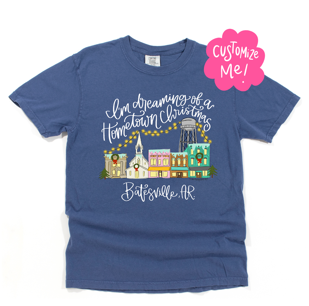 Blue t-shirt with Christmas-themed design and 'I'm Dreaming of a Hometown Christmas' text on a white background