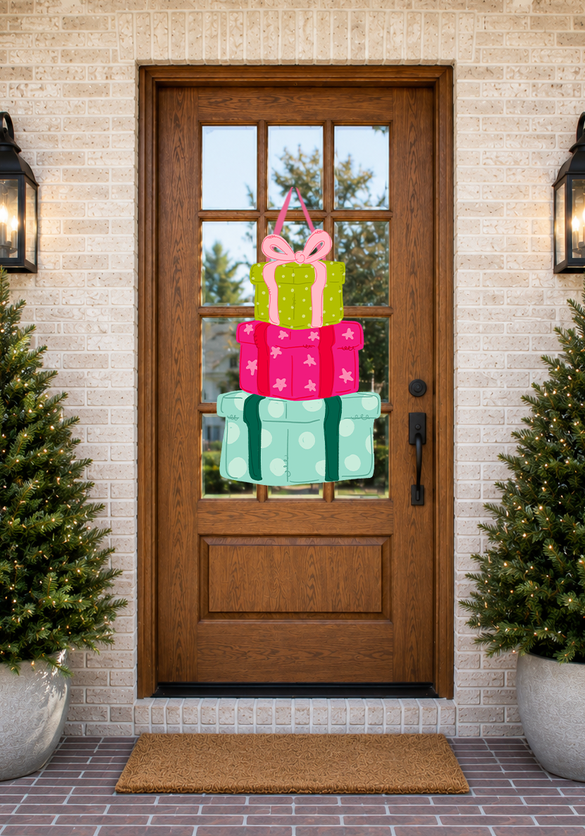 Decorative door with gift box design, flanked by two potted plants on a brick patio.