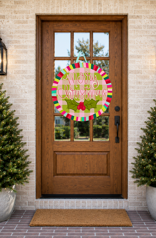 Decorative 'Merry Christmas' wreath on a wooden door with potted plants on either side.