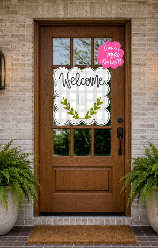 Wooden front door with decorative glass panels, 'Welcome' sign, and pink sign on a brick wall.