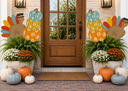 Decorative Thanksgiving scene with pumpkins, turkeys, and potted plants in front of a door.