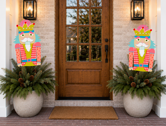 Decorative nutcrackers flanking a door with festive planters.