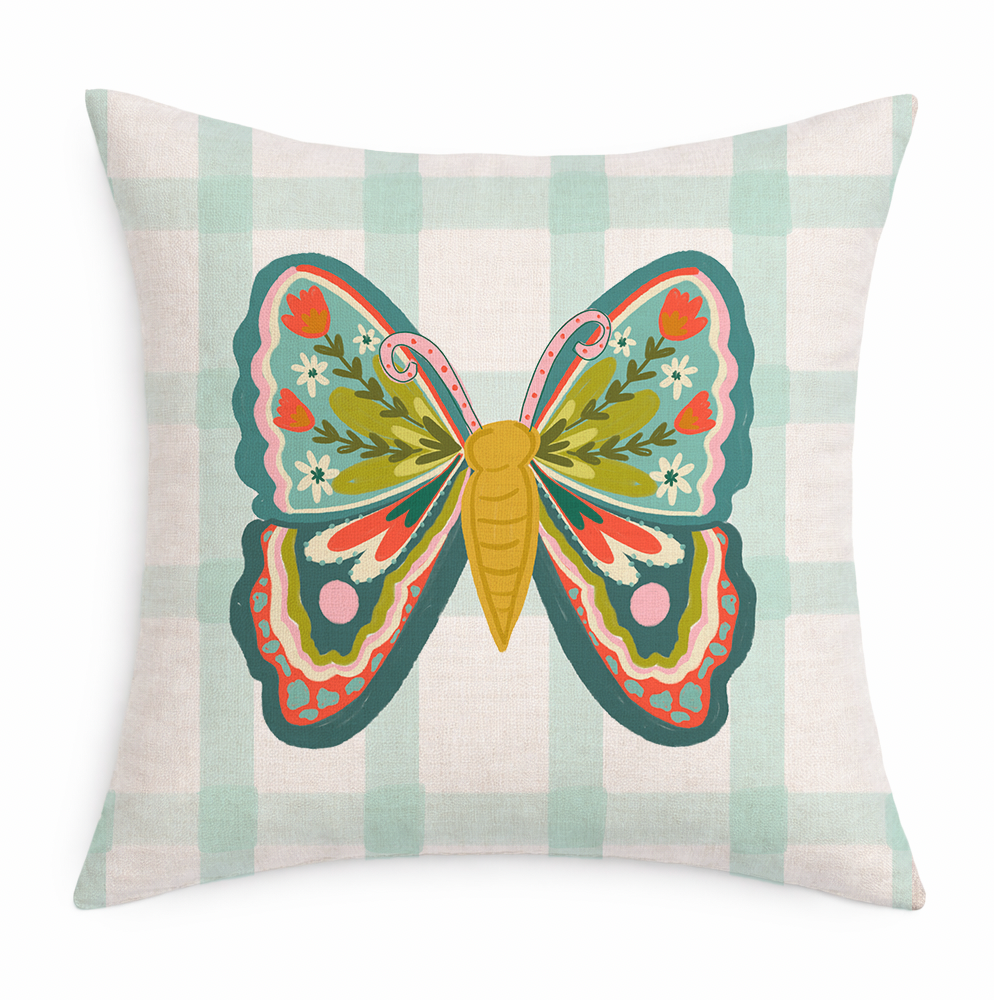 Decorative pillow with a colorful butterfly design on a plaid background