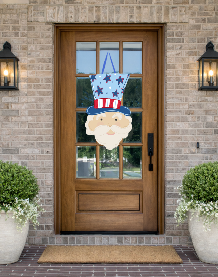 Doodles by Rebekah patriotic Uncle Sam door decor featuring a hand-drawn illustration of Uncle Sam in an American flag-themed hat on a rustic front porch.
