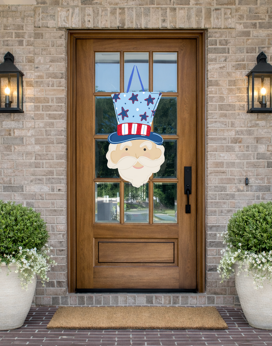 Doodles by Rebekah patriotic Uncle Sam door decor featuring a hand-drawn illustration of Uncle Sam in an American flag-themed hat on a rustic front porch.