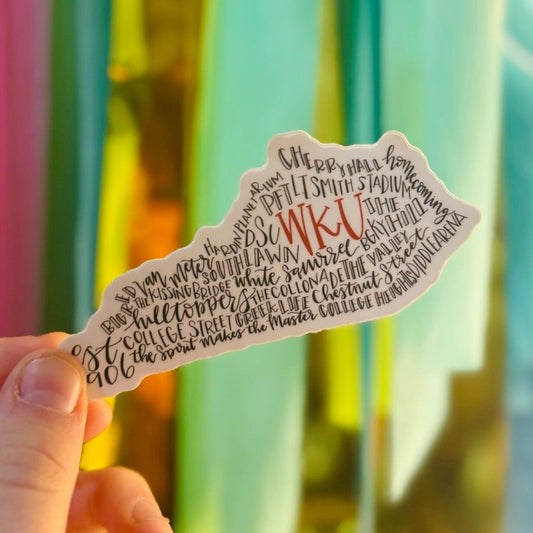 Doodles by Rebekah WKU (Western Kentucky University) state silhouette sticker. This whimsical hand-painted vinyl decal features campus landmarks and traditions in a typography map design, making it a perfect graduation or spirit gift for Hilltoppers to use on water bottles and laptops.