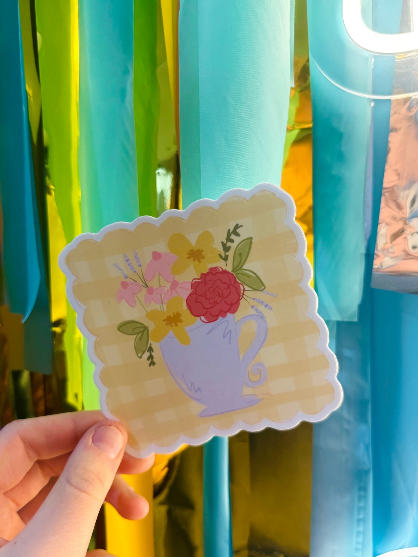 Doodles by Rebekah floral teacup sticker with scalloped edges. This whimsical vinyl decal features a hand-painted spring flower bouquet in a lavender tea cup, perfect for decorating laptops, water bottles, or journals.